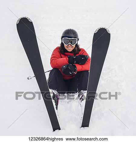 A skier in a red coat sitting in the snow with her skis pointed upwards; Whistler, British Columbia, Canada View Large Photo Image Stock Photograph - A skier in a red coat sitting in the snow with her skis pointed upwards; Whistler, British Columbia, Canada. Fotosearch