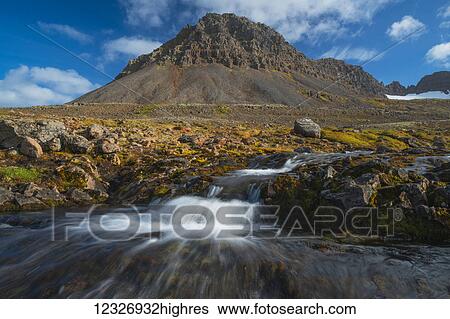 Stock Photograph - A small stream flowing out from the mountains along the Strandir Coast; West Fjords, Iceland. Fotosearch