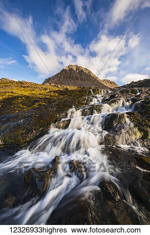 Stock Photograph - A small stream flowing out from the mountains along the Strandir Coast; West Fjords, Iceland. Fotosearch