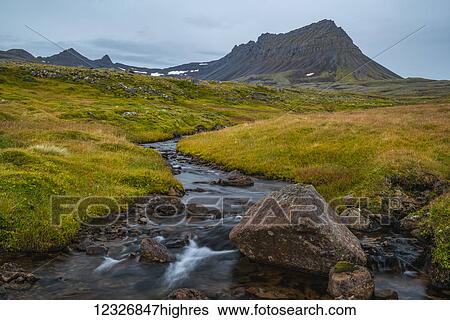 Stock Photograph - A small unnamed stream flows out from the mountains along the Strandir Coast; Westfjords, Iceland. Fotosearch