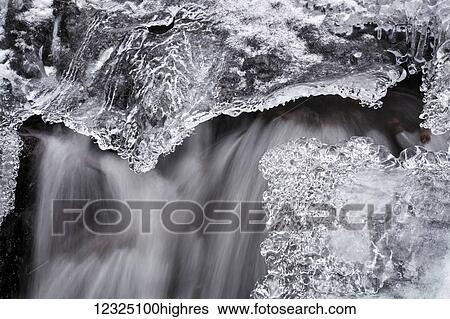 Stock Photograph - A small waterfall and ice in early March, Horse Pasture Brook, a protected wilderness area; Wentworth Valley, Nova Scotia, Canada. Fotosearch