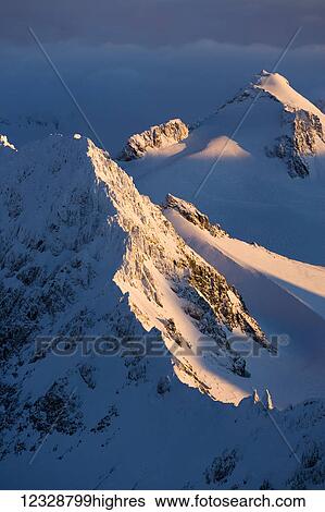 A snow covered mountain covered by shadows and sunlight, Kachemak Bay State Park; Alaska, United States of America View Large Photo Image Stock Photograph - A snow covered mountain covered by shadows and sunlight, Kachemak Bay State Park; Alaska, United States of America. Fotosearch