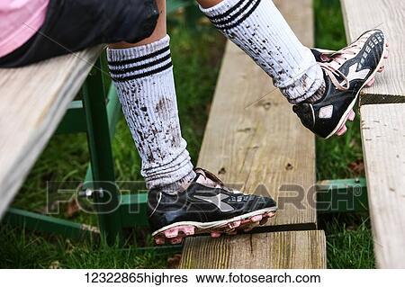 A soccer player sitting on wooden stands wearing cleats and mud splashed socks; Oregon, United States of America View Large Photo Image Stock Photograph - A soccer player sitting on wooden stands wearing cleats and mud splashed socks; Oregon, United States of America. Fotosearch