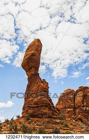 A tall, rugged rock formation in a desert landscape, Arches National Park; Utah, United States of America View Large Photo Image Stock Photograph - A tall, rugged rock formation in a desert landscape, Arches National Park; Utah, United States of America. Fotosearch