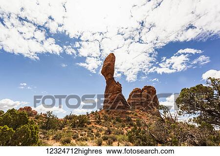 Stock Photograph - A tall, rugged rock formation in a desert landscape, Arches National Park; Utah, United States of America. Fotosearch