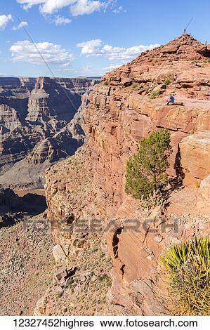 A vertical view of the steep cliff edges of the Grand Canyon, and the tourist viewpoint for photos at the peak of the hiking trail on this mountain edge; Arizona, United States of America View Large Photo Image Stock Photograph - A vertical view of the steep cliff edges of the Grand Canyon, and the tourist viewpoint for photos at the peak of the hiking trail on this mountain edge; Arizona, United States of America. Fotosearch