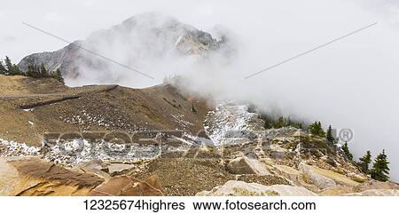 A viewpoint from the top of the mountain shows the trails for hikers to follow to the next peak through the clouds at Kicking Horse Mountain Resort; Golden, British Columbia, Canada View Large Photo Image Stock Photograph - A viewpoint from the top of the mountain shows the trails for hikers to follow to the next peak through the clouds at Kicking Horse Mountain Resort; Golden, British Columbia, Canada. Fotosearch