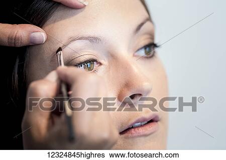 Stock Photograph - A woman having cosmetics applied; Ontario, Canada. Fotosearch