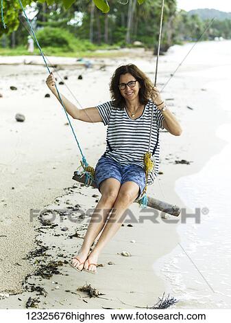 A woman sits on a tree swing on the beach along the Gulf of Thailand; Ko Samui, Chang Wat Surat Thani, Thailand View Large Photo Image Stock Photograph - A woman sits on a tree swing on the beach along the Gulf of Thailand; Ko Samui, Chang Wat Surat Thani, Thailand. Fotosearch