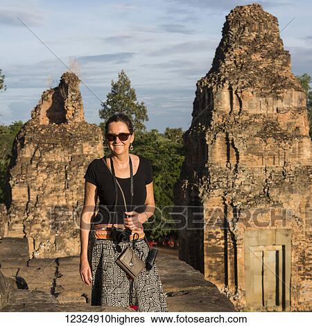 A woman stands posing for the camera at Pre Roup Temple; Krong Siem Reap, Siem Reap Province, Cambodia View Large Photo Image Stock Photograph - A woman stands posing for the camera at Pre Roup Temple; Krong Siem Reap, Siem Reap Province, Cambodia. Fotosearch