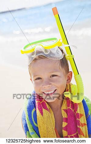 Stock Photograph - A young boy smiling with snorkel gear at the beach; Honolulu, Oahu, Hawaii, United States of America. Fotosearch