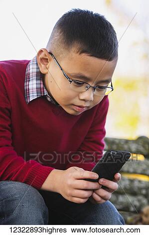 A young boy using a smart phone; Washington, United States of America View Large Photo Image Stock Photograph - A young boy using a smart phone; Washington, United States of America. Fotosearch