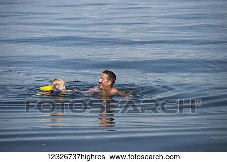 A young Caucasian girl swims with her dad in Seneca Lake, upstate New York; Dresden, New York, United States of America View Large Photo Image Stock Photograph - A young Caucasian girl swims with her dad in Seneca Lake, upstate New York; Dresden, New York, United States of America. Fotosearch