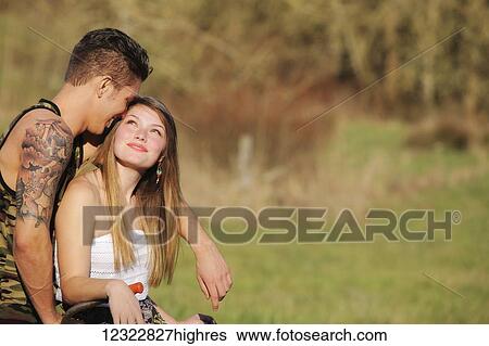 A young couple spends time together in a park; Oregon, United States of America View Large Photo Image Stock Photograph - A young couple spends time together in a park; Oregon, United States of America. Fotosearch
