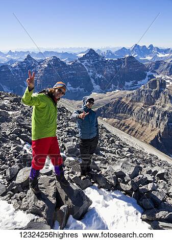 Stock Photograph - A young man and young woman posing while climbing in the Rocky mountains; Banff, Alberta, Canada. Fotosearch