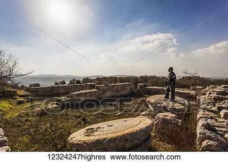 A young man stands on the base of a pillar at a ruins site; Sabasita, Samaria, Israel View Large Photo Image Stock Photograph - A young man stands on the base of a pillar at a ruins site; Sabasita, Samaria, Israel. Fotosearch