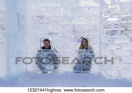 Stock Photograph - A young tourist couple poses inside of an ice castle build on the ice at Lake Louise in Banff National Park; Lake Louise, Alberta, Canada. Fotosearch
