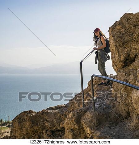 A young woman poses while hiking in Ein Gedi, with the Dead Sea in the background, Dead Sea District; South District, Israel View Large Photo Image Stock Photograph - A young woman poses while hiking in Ein Gedi, with the Dead Sea in the background, Dead Sea District; South District, Israel. Fotosearch
