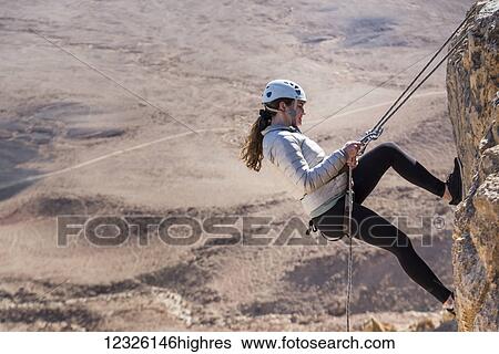 A young woman rappelling into Ramon Crater, Ramon Nature Reserve; Mitzpe Ramon, South District, Israel View Large Photo Image Stock Photograph - A young woman rappelling into Ramon Crater, Ramon Nature Reserve; Mitzpe Ramon, South District, Israel. Fotosearch