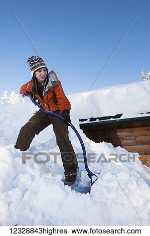 A young woman removes snow from the roof of her house; Homer, Alaska, United States of America View Large Photo Image Stock Photograph - A young woman removes snow from the roof of her house; Homer, Alaska, United States of America. Fotosearch