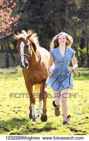 A young woman runs in a field with a horse; Oregon, United States of America View Large Photo Image Stock Photograph - A young woman runs in a field with a horse; Oregon, United States of America. Fotosearch