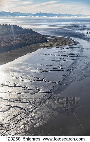 Aerial perspective of the shoreline at Kincaid Park, the low tide revealing patterns in the silt below, the Kenai Mountains in the background, South-central Alaska; Alaska, United States of America View Large Photo Image Stock Photograph - Aerial perspective of the shoreline at Kincaid Park, the low tide revealing patterns in the silt below, the Kenai Mountains in the background, South-central Alaska; Alaska, United States of America. Fotosearch