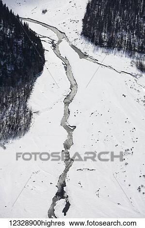 Stock Photograph - Aerial view of a river running through snow in the Kenai mountains in winter, Kachemak Bay State Park; Alaska, United States of America. Fotosearch
