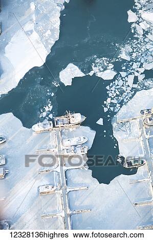 Stock Photograph - Aerial view of boat moored in the Homer small boat harbor in winter, Southcentral Alaska, USA. Fotosearch