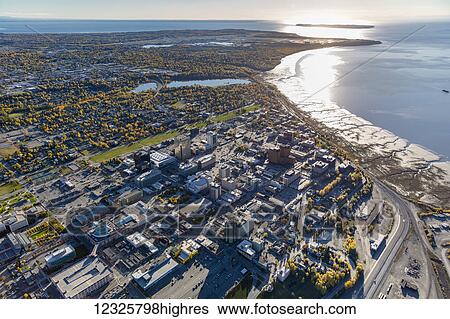 Stock Photograph - Aerial view of downtown Anchorage and the Park Strip, Cook Inlet and Turnagain Arm visible in the background, autumn coloured trees filling the city, South-central Alaska; Anchorage, Alaska, United States of America. Fotosearch