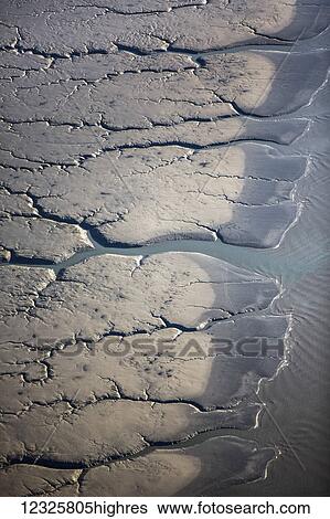 Stock Photograph - Aerial view of patterns made by water draining over the Silt Mud Flats along Cook Inlet, South-central Alaska; Alaska, United States of America. Fotosearch
