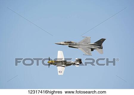 An F-16 fighter jet flying formation with a WWII P-51 Mustang; Edmonton, Alberta, Canada View Large Photo Image Stock Photograph - An F-16 fighter jet flying formation with a WWII P-51 Mustang; Edmonton, Alberta, Canada. Fotosearch