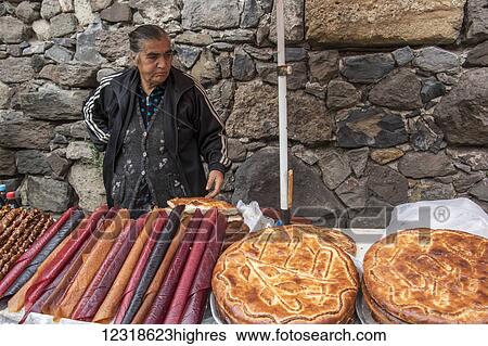Stock Photograph - Armenian woman selling fruit leather and gata, sweet, egg-enriched bread; Garni, Azat Valley, Armenia. Fotosearch