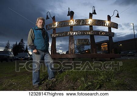 Artist Leo Vait standing with custom sign he designed and built with artist and welder Doug Schweisow for the Kenai Peninsula College Kachemak Bay Campus. View Large Photo Image Stock Photograph - Artist Leo Vait standing with custom sign he designed and built with artist and welder Doug Schweisow for the Kenai Peninsula College Kachemak Bay Campus.. Fotosearch