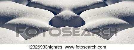Stock Photograph - Artistic montage of snow contouring a creek bed with graphic designs of curving highlights and shadows; Lake Louise, Alberta, Canada. Fotosearch