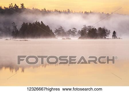Stock Photograph - Autumn morning sunrise at Millers Lake; Nova Scotia, Canada. Fotosearch