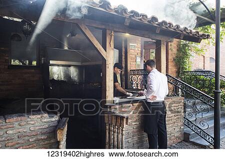 Stock Photograph - Barbecue station of the Bread House Georgian Restaurant; Tbilisi, Georgia. Fotosearch
