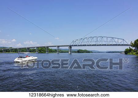 Stock Photograph - Boater on Mississippi River approaches WabashaNelson Bridge; Wabasha, Minnesota, United States of America. Fotosearch