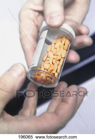Stock Photography - Bottle of pills being handed to patient. Fotosearch