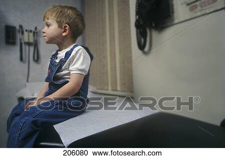 Boy sitting on examination room table View Large Photo Image Stock Image - Boy sitting on examination room table. Fotosearch