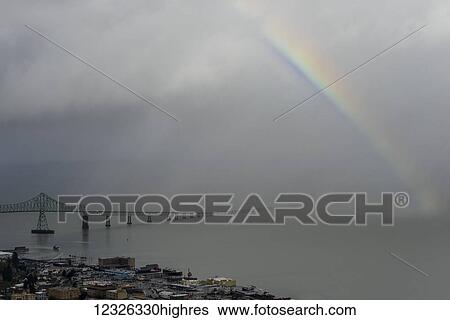 Stock Photograph - Bridge disappears into the mist with a rainbow over the Columbia River; Astoria, Oregon, United States of America. Fotosearch