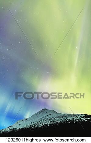 Stock Photograph - Bright green and purple Aurora Borealis dances over the Kenai Mountains, Moose Pass, Kenai Peninsula, South-central Alaska; Alaska, United States of America. Fotosearch