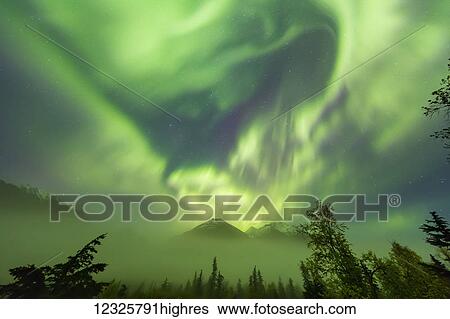 Stock Photograph - Bright green aurora borealis dances over the Kenai Mountains, Moose Pass, Kenai Peninsula, South-central Alaska; Alaska, United States of America. Fotosearch
