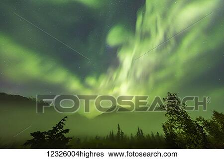 Stock Photograph - Bright green Aurora Borealis dances over the Kenai Mountains, Moose Pass, Kenai Peninsula, South-central Alaska; Alaska, United States of America. Fotosearch