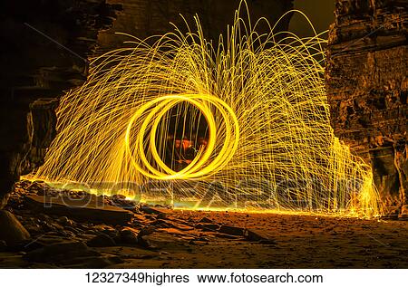 Bright yellow sparks moving in a circular motion off the rocks; South Tyneside, Tyne and Wear, England View Large Photo Image Stock Photograph - Bright yellow sparks moving in a circular motion off the rocks; South Tyneside, Tyne and Wear, England. Fotosearch