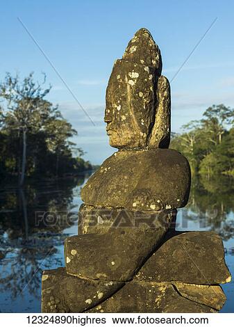 Stock Photograph - Buddhist statue, South Gate, Angkor Thom; Krong Siem Reap, Siem Reap Province, Cambo. Fotosearch