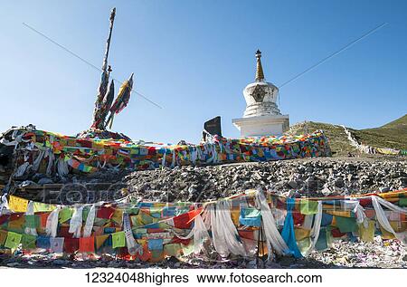 Stock Photograph - Buddhist stupa and Tibetan flags on the road near Litang village, first Tibetan town from Chengdu; Litang, Sichuan, China. Fotosearch