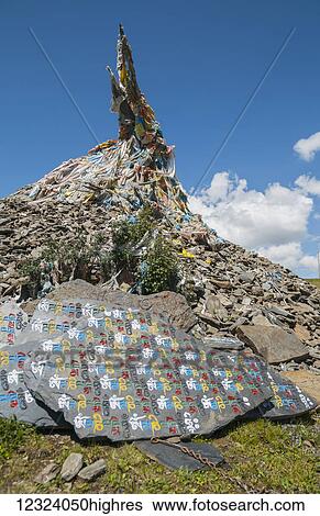 Stock Photograph - Buddhist stupa and Tibetan flags on the road near Litang village, first Tibetan town from Chengdu; Litang, Sichuan, China. Fotosearch