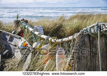 Buoys and a wooden boat on the shore among tall grasses with rough waves in the ocean View Large Photo Image Stock Photograph - Buoys and a wooden boat on the shore among tall grasses with rough waves in the ocean. Fotosearch