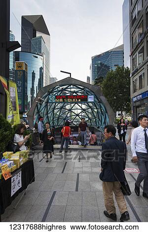 Stock Photograph - Businessmen and business woman commuting to work by an entrance to the underground subway; Seoul, Korea. Fotosearch