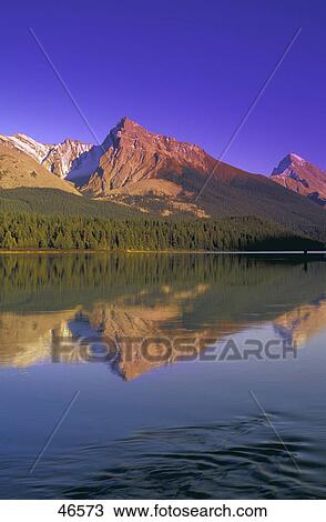 Calm lake with mountain behind on a clear day View Large Photo Image Stock Image - Calm lake with mountain behind on a clear day. Fotosearch